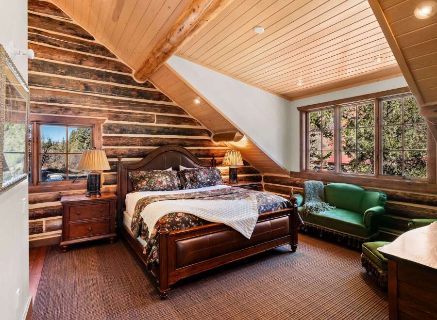 This stunning bedroom features a rustic log cabin aesthetic, perfect for a cozy retreat.