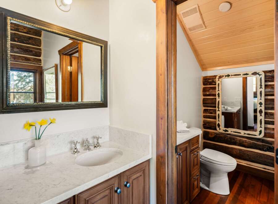 This charming bathroom features a rustic design with wooden accents and a marble countertop.