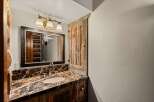This stunning bathroom features a rustic design with a beautiful marble countertop and a wooden vanity.