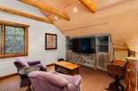 This cozy living space features a rustic aesthetic with wooden beams and a paneled ceiling.