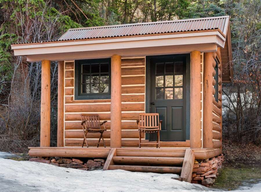 This charming cabin offers a rustic retreat with its log construction and inviting porch.