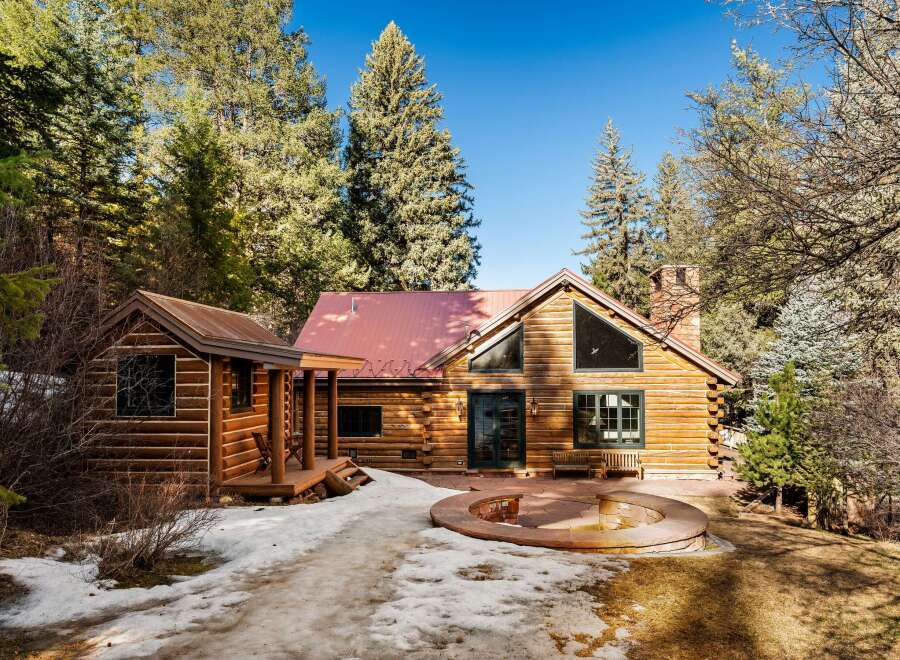 Nestled amidst towering trees, this charming log cabin offers a serene retreat.