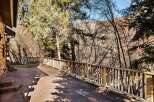 Enjoy the tranquility of this stunning property with a beautiful stone patio and a charming wooden railing.
