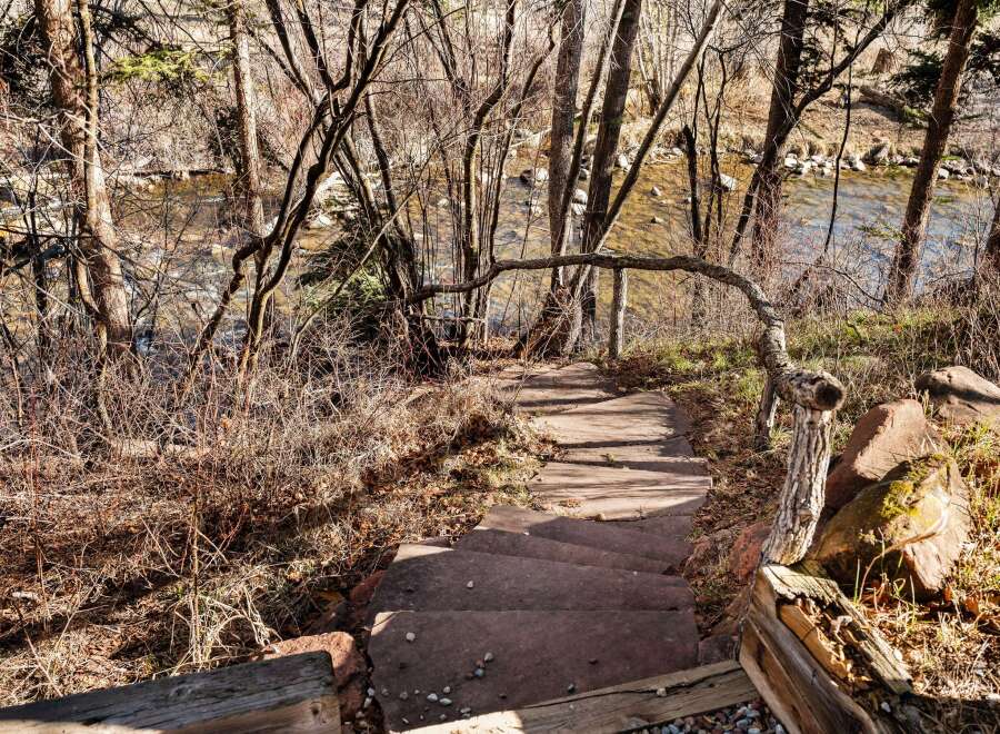 Discover a hidden gem with this stunning property featuring a picturesque staircase leading to a serene river.