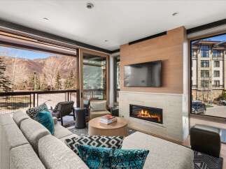 Experience luxury living in this stunning property, featuring a cozy fireplace and a modern TV setup, perfect for relaxing evenings.