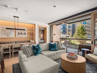 Step into luxury with this stunning property, featuring a modern living space with a comfortable sectional sofa and stylish accent pillows.