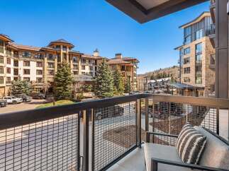Enjoy stunning views from this luxurious balcony overlooking a beautiful mountain resort.