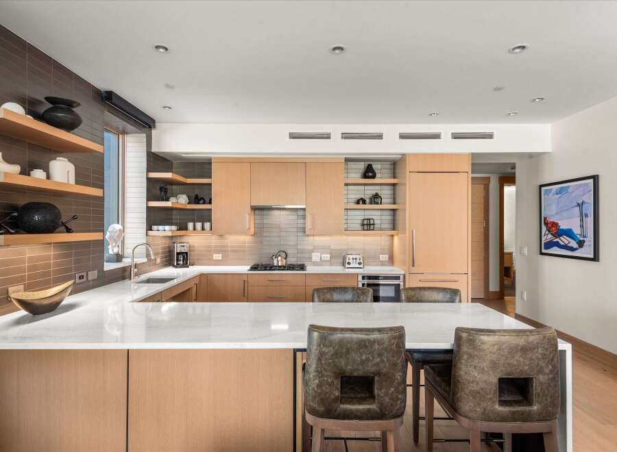 This stunning kitchen boasts a modern design with sleek cabinetry and a spacious island, perfect for both cooking and entertaining.