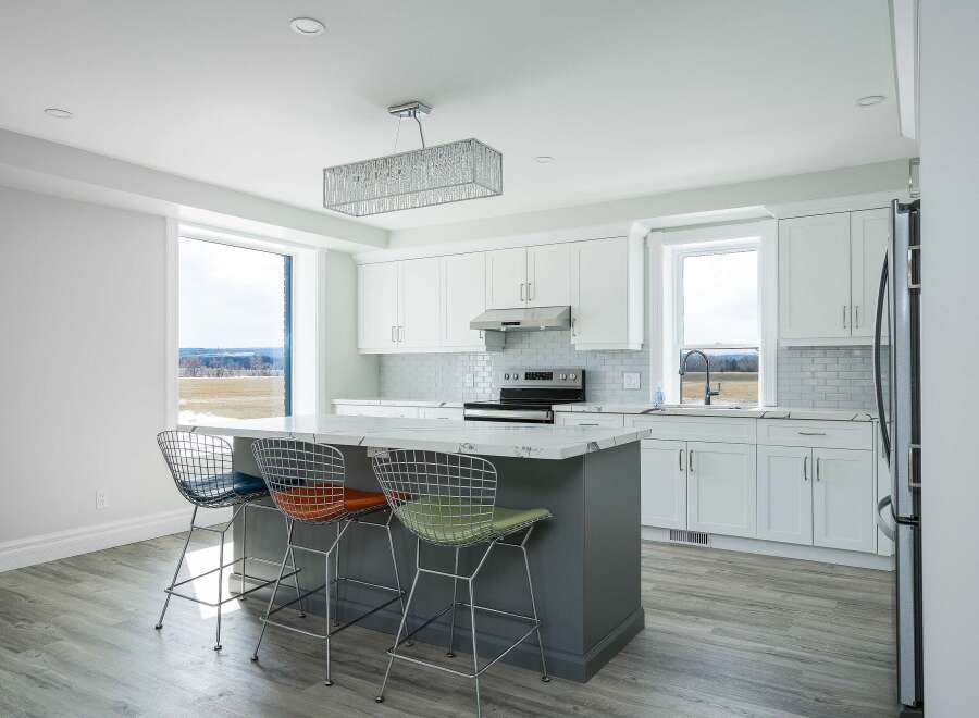 This stunning kitchen boasts a modern design with sleek white cabinetry and a spacious island, perfect for both cooking and entertaining.