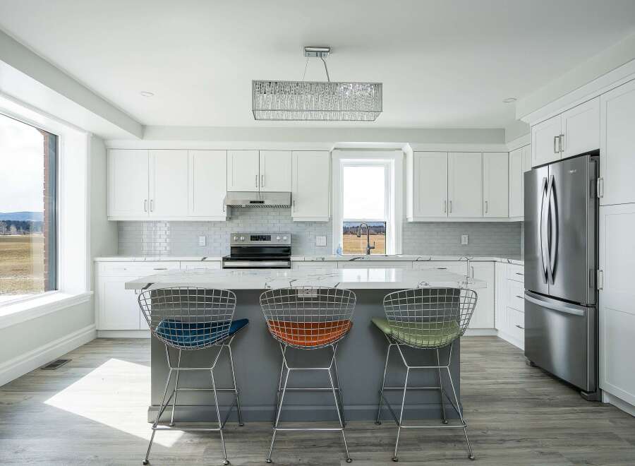 This stunning kitchen boasts modern design with sleek white cabinetry and a spacious island.