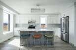This stunning kitchen boasts modern design with sleek white cabinetry and a spacious island.