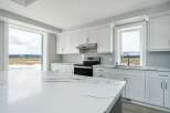 This stunning kitchen boasts a modern design with sleek white cabinetry and a spacious island, perfect for culinary enthusiasts.