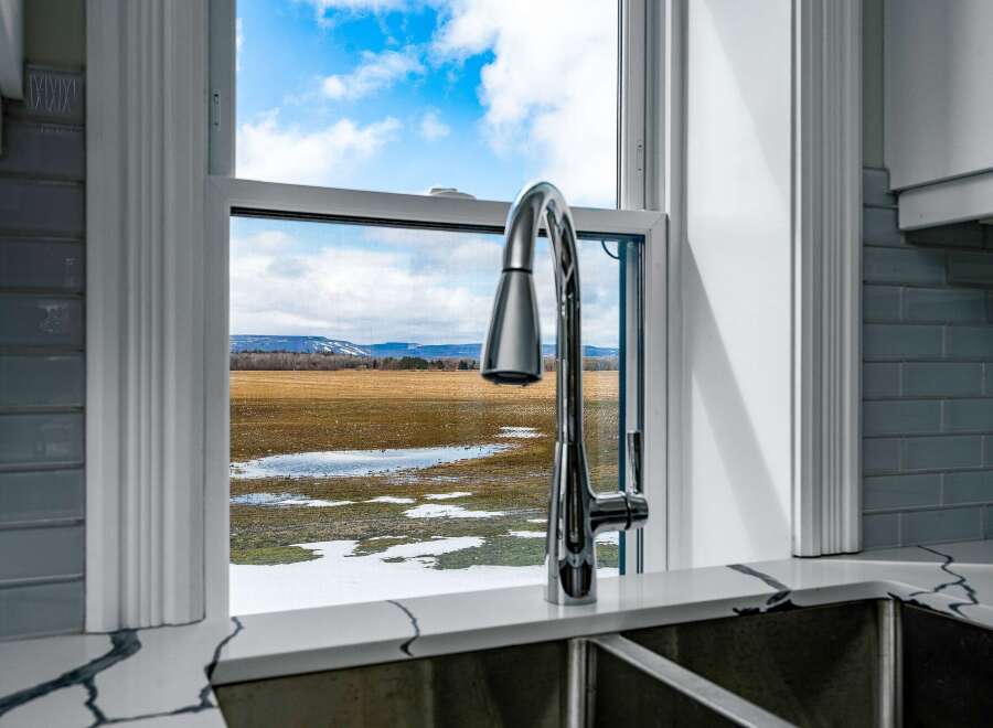 Enjoy breathtaking views from this stunning kitchen! This property boasts a modern kitchen with a sleek faucet and a beautiful countertop.
