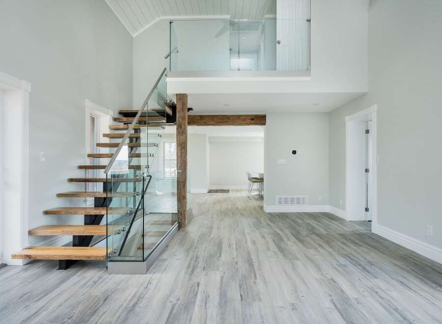 This stunning property boasts a modern interior with a floating staircase and glass railings, creating an open and airy feel.