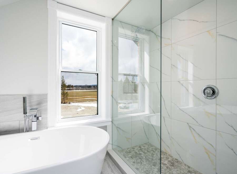 This luxurious bathroom features a modern design with a freestanding tub and a walk-in shower.