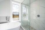 This luxurious bathroom features a modern design with a freestanding tub and a walk-in shower.