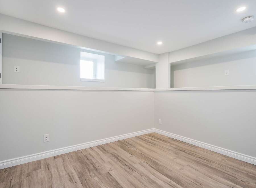 Discover the potential of this versatile space! This room features a clean, modern design with neutral walls and a stylish wood-look floor.