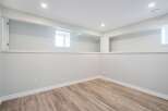 Discover the potential of this versatile space! This room features a clean, modern design with neutral walls and a stylish wood-look floor.