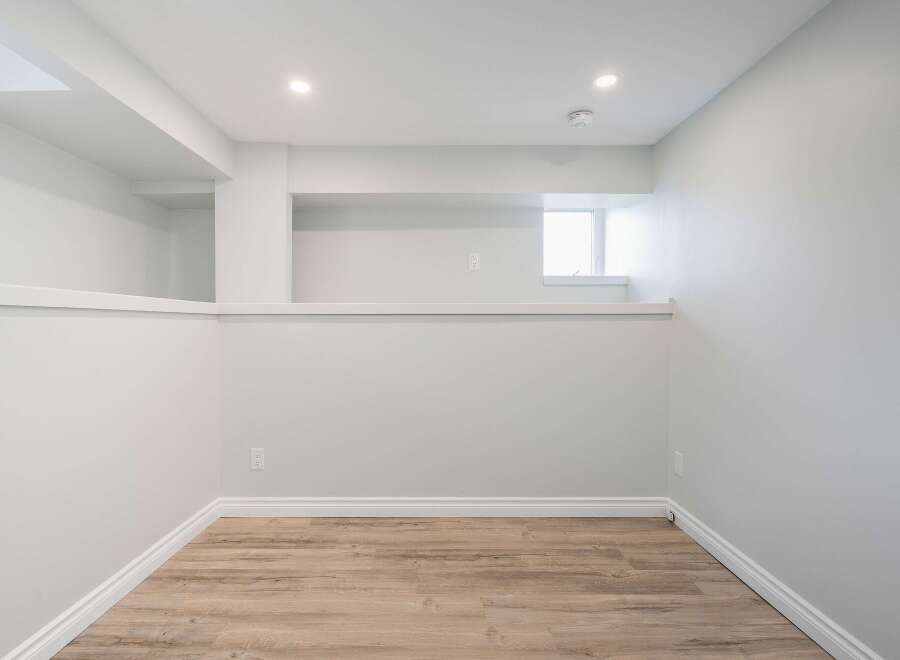 Discover the potential of this versatile space! This room features a clean, modern design with neutral walls and a stylish wood-look floor.