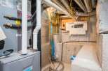 Explore the hidden infrastructure of this property, showcasing a well-maintained furnace and electrical panel.