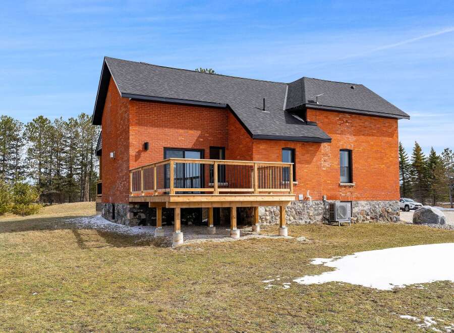 This stunning brick home boasts a beautiful wooden deck, perfect for enjoying the outdoors.