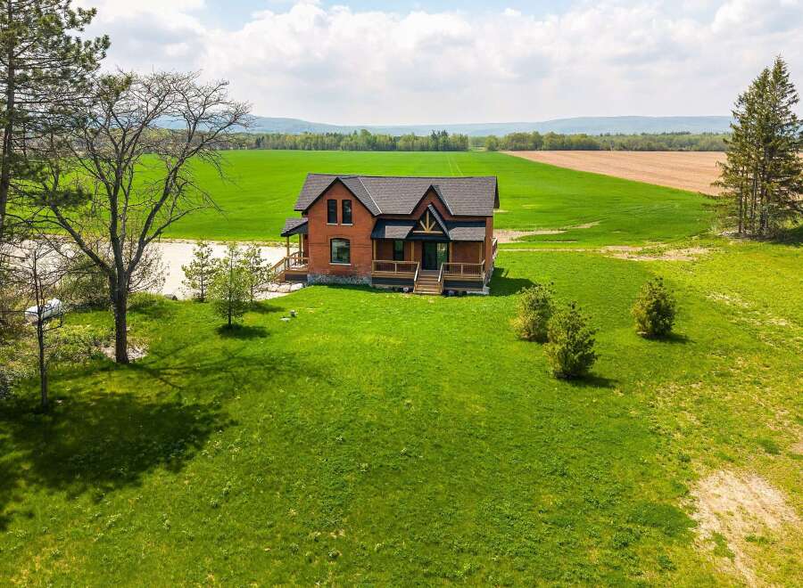 This stunning property boasts a charming brick house with a welcoming porch, perfect for enjoying the serene surroundings.