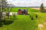 This stunning property boasts a charming brick house with a welcoming porch, perfect for enjoying the serene surroundings.