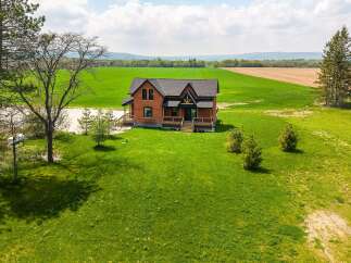 This stunning property boasts a charming brick house with a welcoming porch, perfect for enjoying the serene surroundings.