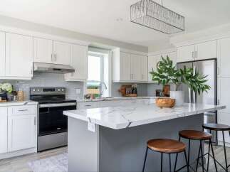 This stunning kitchen boasts a modern design with sleek white cabinetry and a spacious island, perfect for both cooking and entertaining.