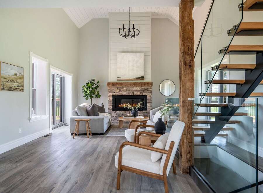 Step into luxury with this stunning living space, featuring a cozy fireplace and a modern staircase.