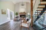 Step into luxury with this stunning living space, featuring a cozy fireplace and a modern staircase.