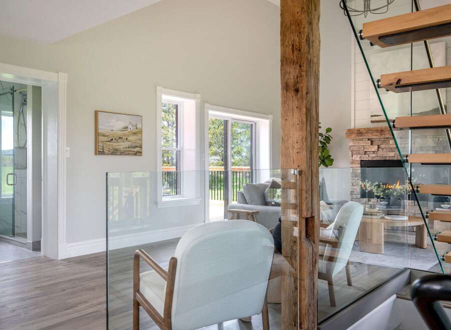 This stunning property boasts a modern interior with a rustic touch, featuring a beautiful wooden beam and a cozy fireplace.