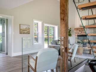 This stunning property boasts a modern interior with a rustic touch, featuring a beautiful wooden beam and a cozy fireplace.
