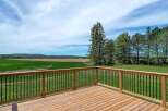 Enjoy breathtaking views from this stunning property! This home features a spacious wooden deck, perfect for outdoor entertaining and relaxation.