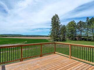 Enjoy breathtaking views from this stunning property! This home features a spacious wooden deck, perfect for outdoor entertaining and relaxation.
