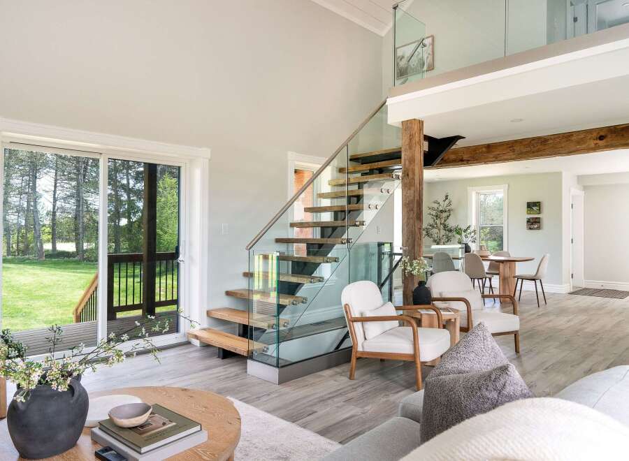 This stunning property boasts a modern interior with a sleek glass staircase and an open-concept living area.
