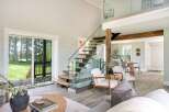 This stunning property boasts a modern interior with a sleek glass staircase and an open-concept living area.