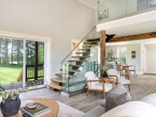 This stunning property boasts a modern interior with a sleek glass staircase and an open-concept living area.