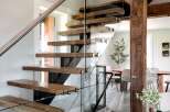 This stunning property boasts a modern staircase with floating wooden steps and sleek glass railings, creating a seamless transition between floors.