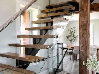 This stunning property boasts a modern staircase with floating wooden steps and sleek glass railings, creating a seamless transition between floors.