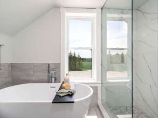 Indulge in the luxury of this stunning bathroom, featuring a sleek, modern soaking tub.