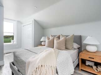 This serene bedroom offers a tranquil retreat with its soft color palette and natural light.