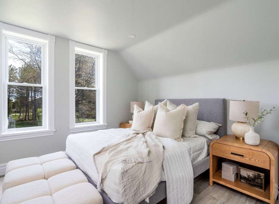 This serene bedroom offers a tranquil retreat with its soft color palette and natural light.