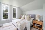 This serene bedroom offers a tranquil retreat with its soft color palette and natural light.