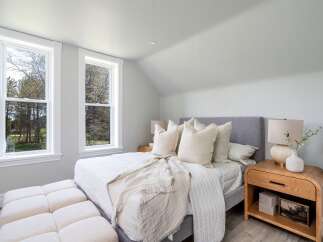 This serene bedroom offers a tranquil retreat with its soft color palette and natural light.