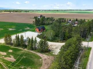 Discover this stunning property featuring a charming house nestled amidst lush greenery and expansive fields.