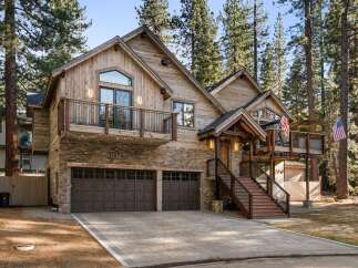 This stunning property boasts a rustic exterior with a combination of wood and stone, creating a warm and inviting atmosphere.