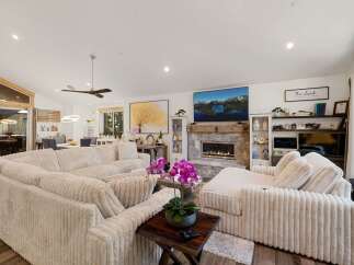 Step into luxury with this stunning living room, featuring a cozy sectional sofa and a beautiful fireplace.