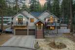 This stunning property boasts a rustic charm with its wooden exterior and stone accents, nestled in a serene, wooded setting.