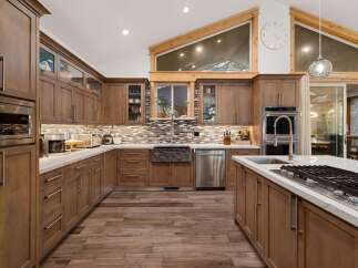 This stunning kitchen boasts custom cabinetry, offering ample storage and a warm, inviting atmosphere.
